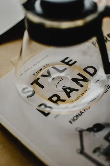Deux hommes d’affaires se serrent la main à un bureau, avec des graphiques de marché boursier affichés sur un ordinateur portable.